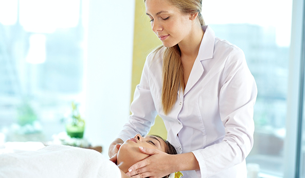 massage therapist massaging a woman's neck